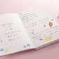 A5 notebook open with writing on graph paper and cute doodle decorations