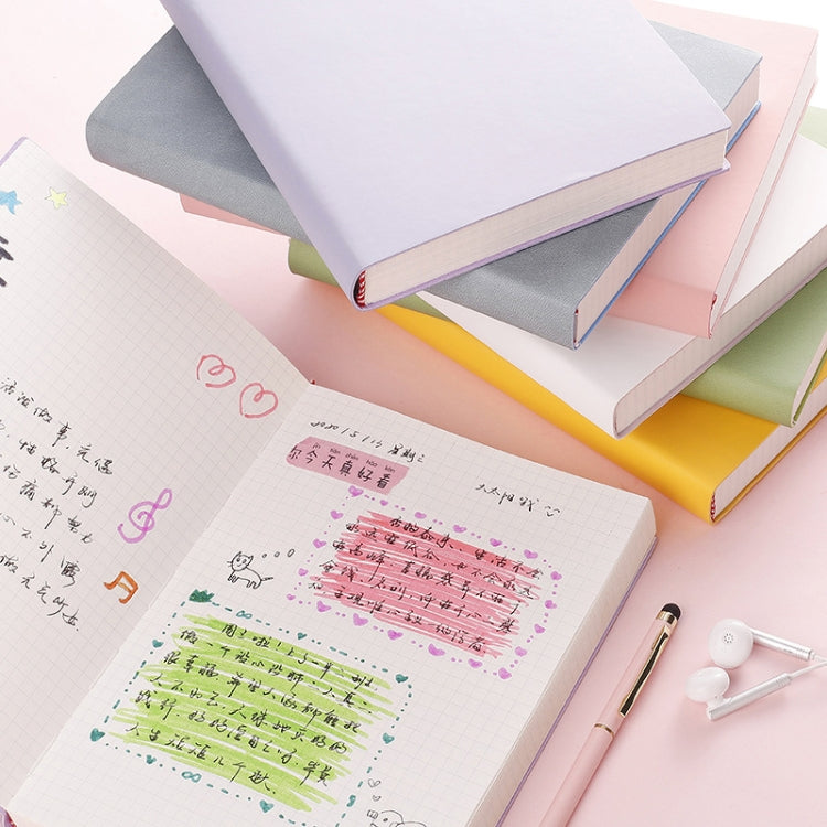 Stack of A5 notebooks with colorful covers, one open to graph paper writing