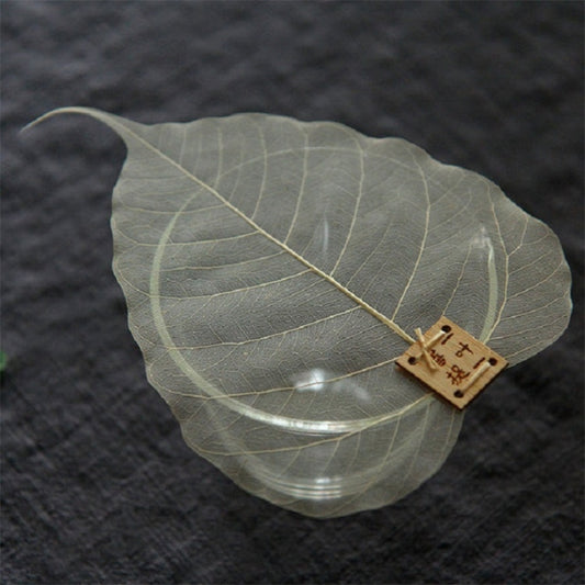 Bodhi leaf tea infuser filter with wooden label and clear glass beneath