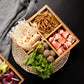 Bamboo compartment platter with divided sections filled with assorted sliced foods for serving.