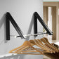 Black wall-mounted drying rack with hooks holding wooden hangers