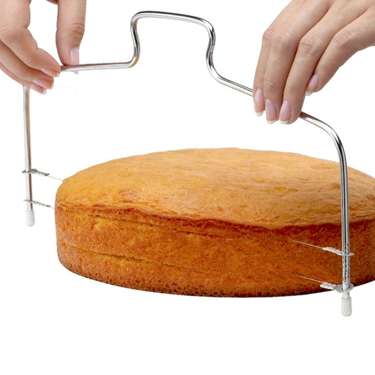 Adjustable wire cake cutter slicing a round cake; wire frame with leveling feet