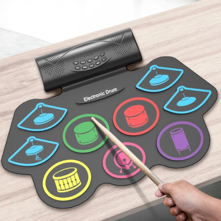 Electronic drum pad set on wood table with mallet and glowing colored pads