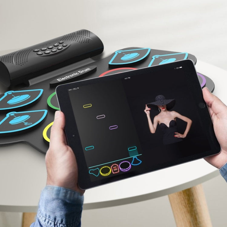 Electronic drum pad set with colored pads and tablet display held in hands