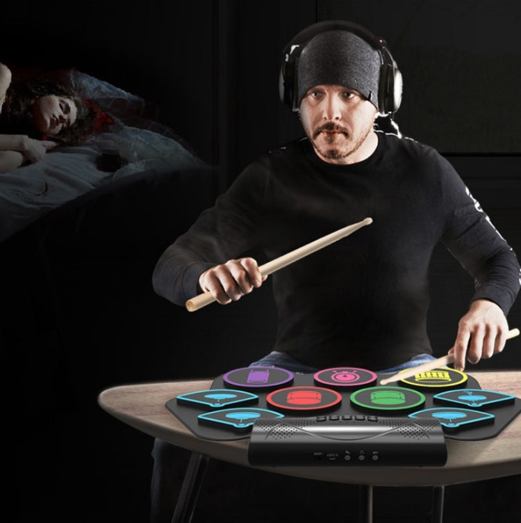 Headphones-wearing player using drumsticks on electronic drum pad