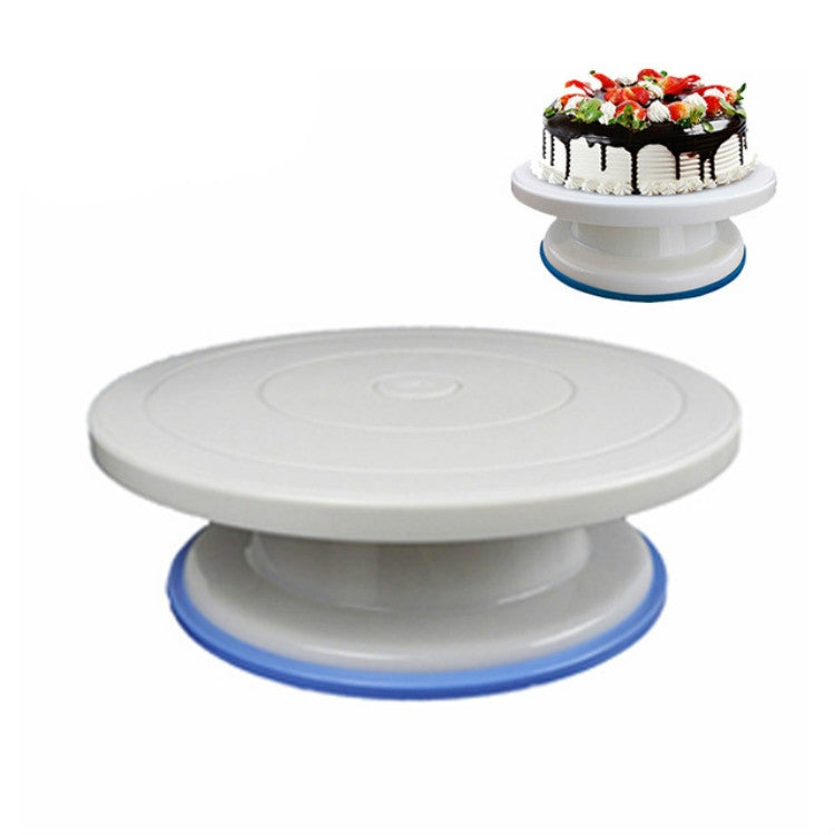 White plastic cake turntable holding a decorated cake with piped frosting