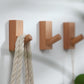 Wood wall hooks with rounded pegs holding a braided rope