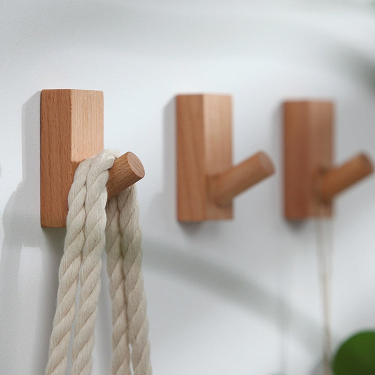 Wood wall hooks with rounded pegs holding a braided rope