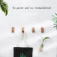 Wood wall hooks with rounded pegs holding rope bag and a small plant pot