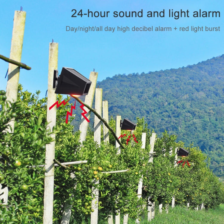 Black outdoor alarm sensor on a fence post with glowing red light