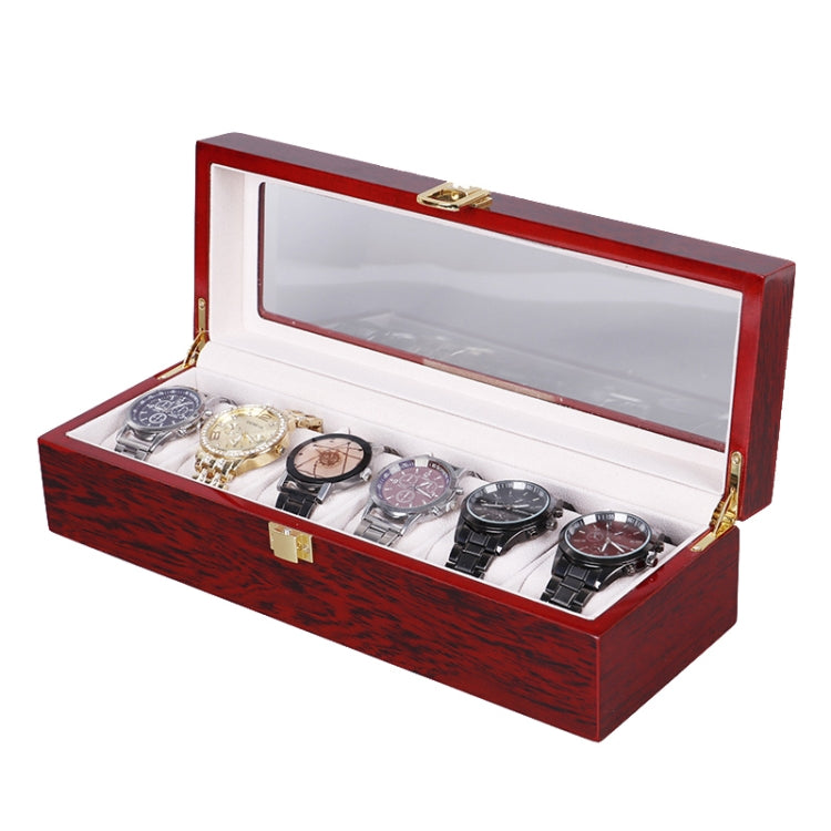 Red wooden watch storage box open with clear window lid and several watch slots