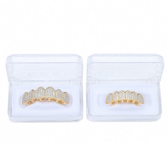 Zircon grill braces set in two clear cases, gold-toned and silver-toned pieces