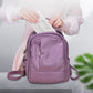 White UV handheld phone sterilizer held near purple mini backpack