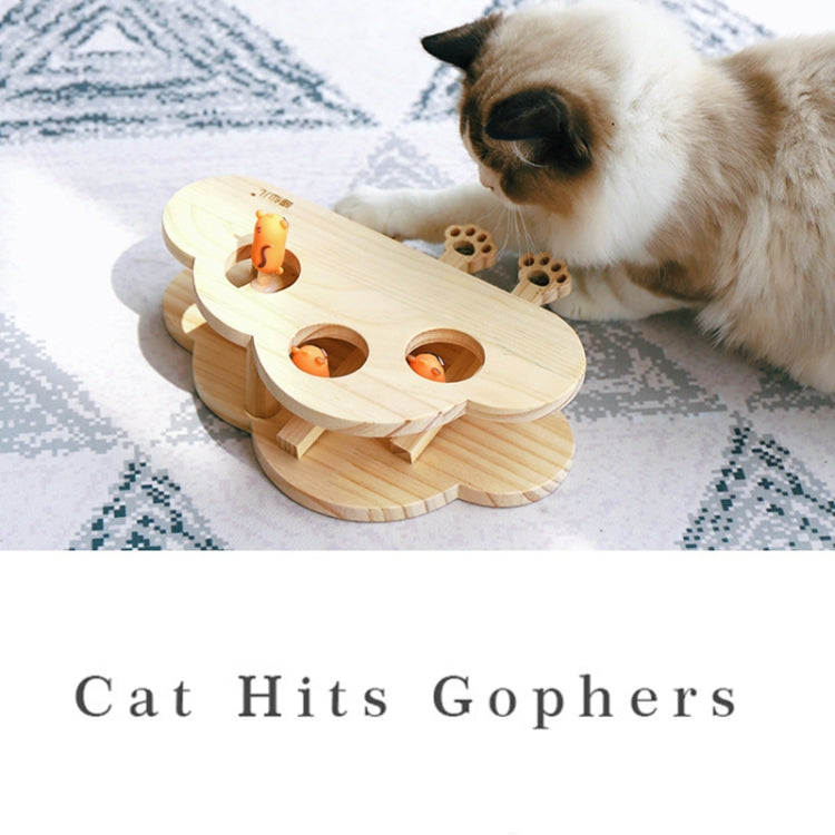 Wooden cat puzzle toy with paw-shaped openings and orange plush ball toys.