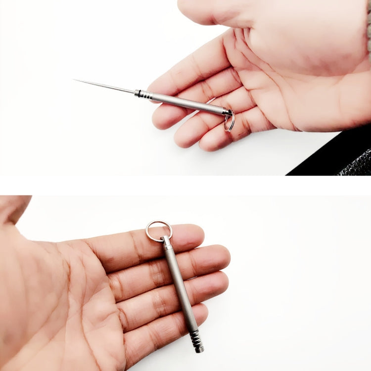 Metal toothpick holder with key ring, shown in hand with pin-style toothpick extended