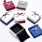 Assorted jewelry gift boxes with ribbon bows; one open box shows black interior.