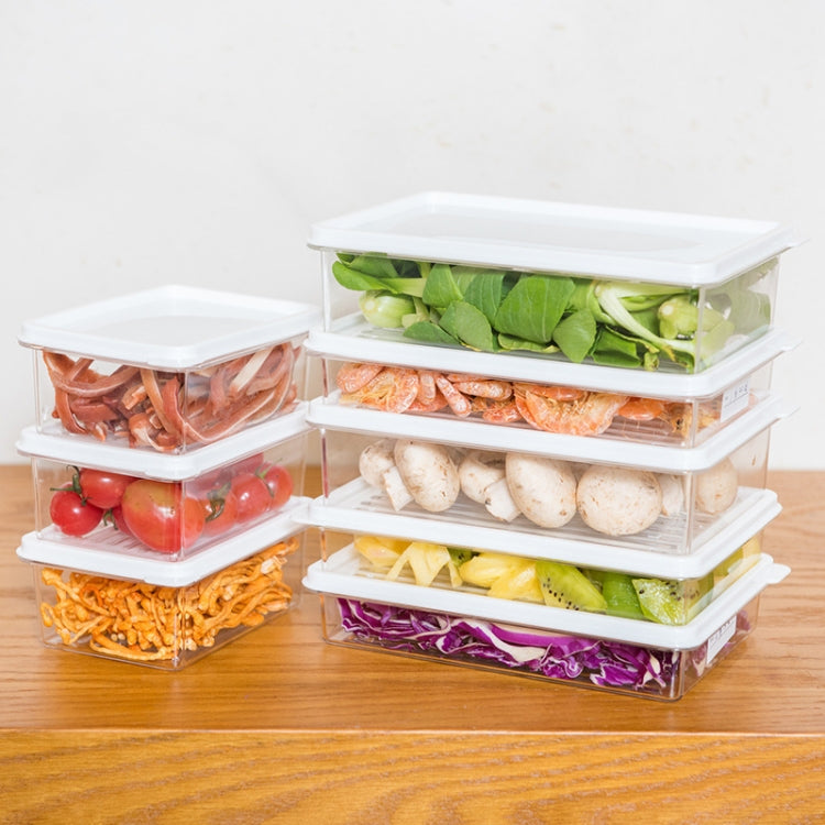 Stack of transparent refrigerator storage boxes filled with mixed vegetables