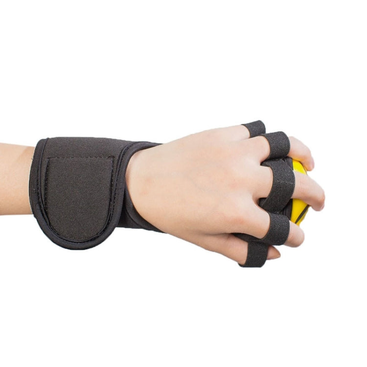 Hand wearing black grip device with thumb opening around yellow strengthening ball