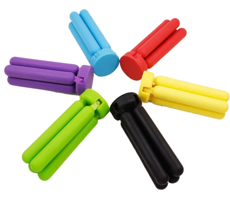 Multicolor cross-shaped folding silicone pot mat with purple, green, yellow, red, and black arms.