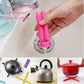 Pink cross-shaped folding silicone pot mat being rinsed under water for easy cleaning.