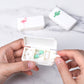 Hand holding open white 3-compartment medicine box with pills in compartments