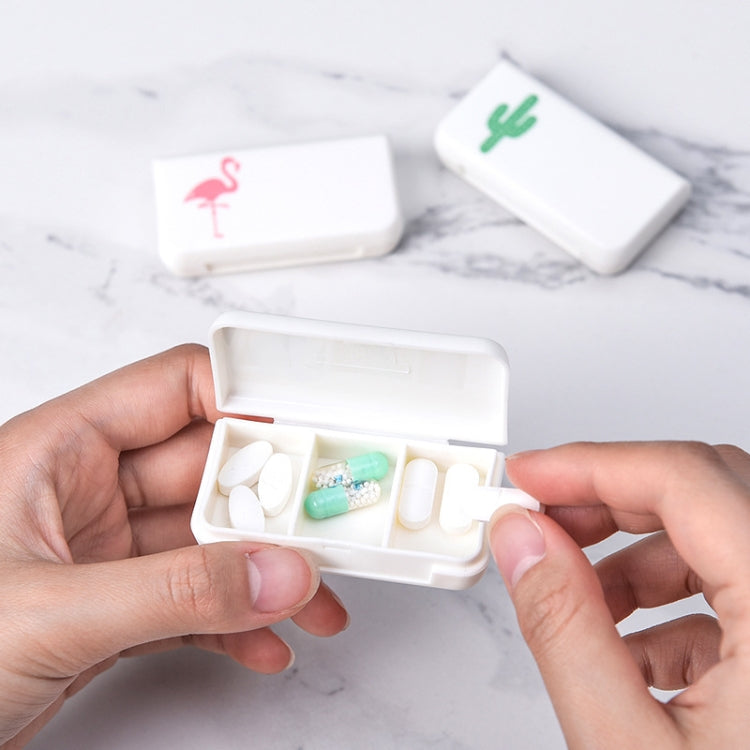 Hand holding open white 3-compartment medicine box with pills in compartments