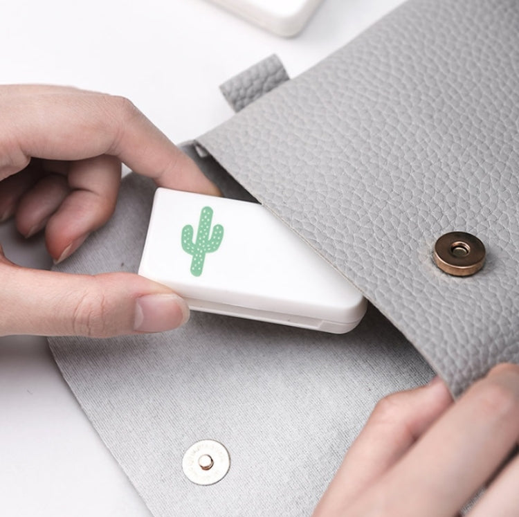 White medicine box with green cactus graphic being placed onto a gray pouch