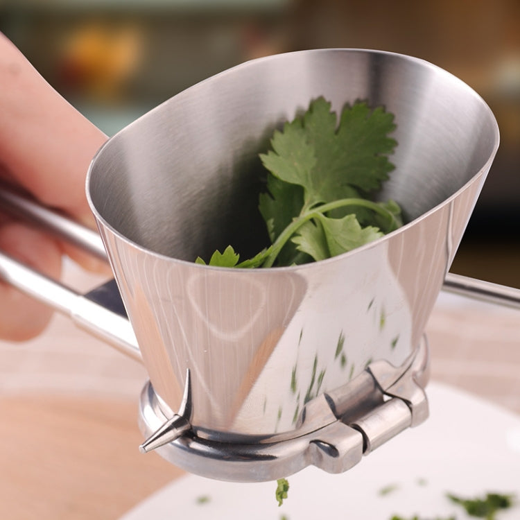 Stainless steel herb chopper bowl holding fresh green herbs with lever blades