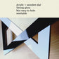 Geometric star wall clock with black and white panels and light wood dial, black hands
