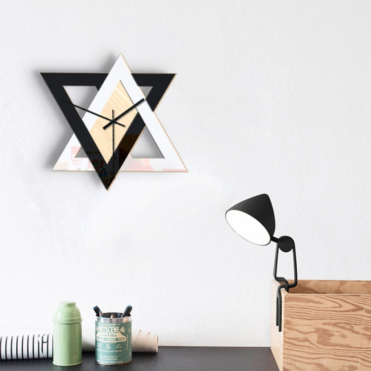 Geometric star wall clock with light wood center, black frame, and black hour and minute hands