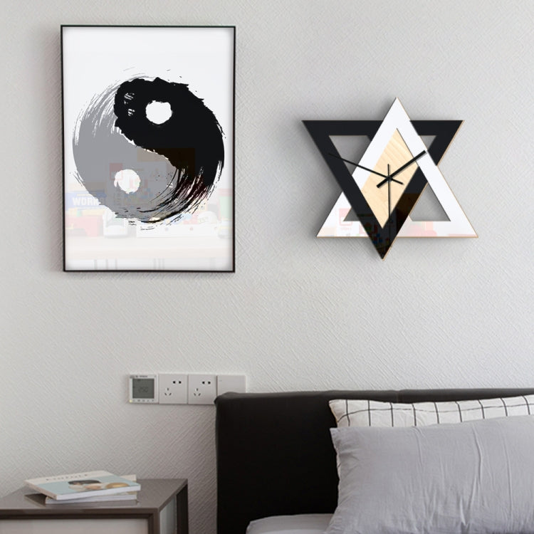 Wall-mounted geometric star clock with black and white frame, light wood dial, black hands