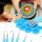 Mandala dotting tool tips and blue pens creating a colorful circular pattern on stone