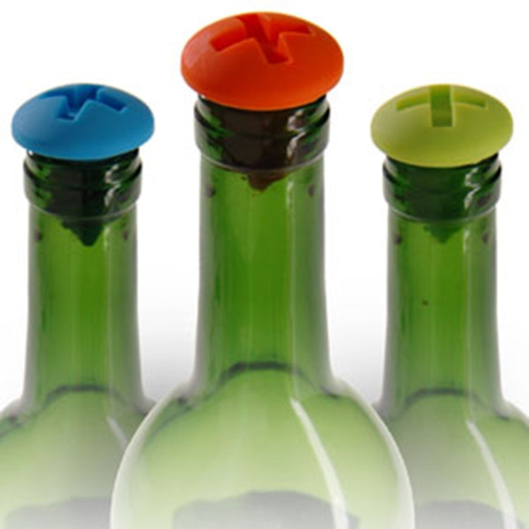 Three screw-style silicone bottle stoppers on glass bottles: blue, orange, green