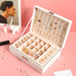 Open white lock jewelry box displaying multiple ring and earring sections
