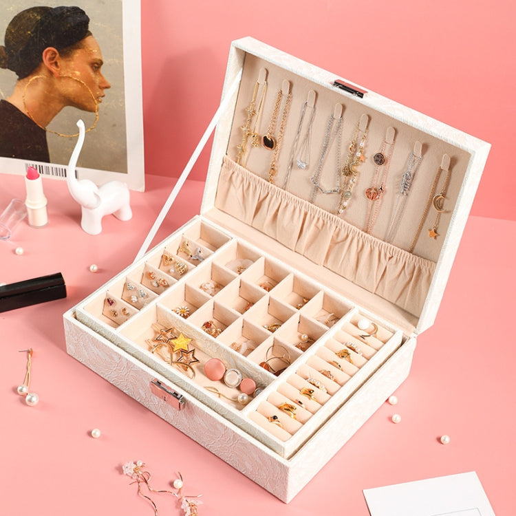 Open white lock jewelry box displaying multiple ring and earring sections