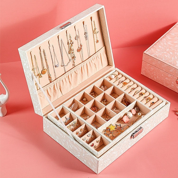 White jewelry desktop storage box open with organized compartments for rings and earrings