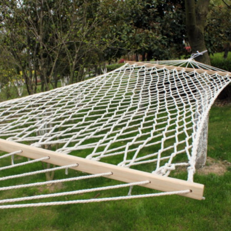 White rope mesh hammock stretched on light wood spreader bars