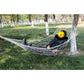 White rope mesh hammock with a seated person and light wood spreader bar