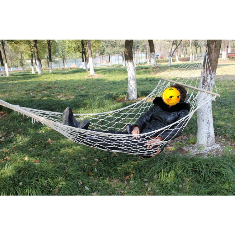 White rope mesh hammock with a seated person and light wood spreader bar