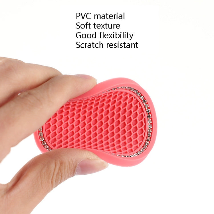 Red/pink honeycomb car cup coaster with rhinestone edge, held between fingers.