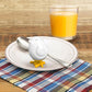 White silicone egg mold on plate with spoon beside it