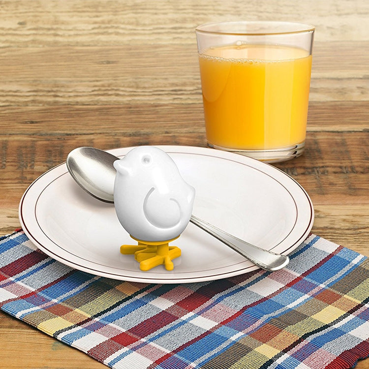 White silicone egg mold on plate with spoon beside it