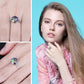 Multicolor faceted gemstone ring on hand, featuring a silver-tone band with decorative swirl
