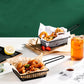 Black wire rectangular snack basket with side handles, filled with fried snacks