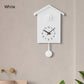 White cuckoo wall clock with round pendulum weight and bird housing on top