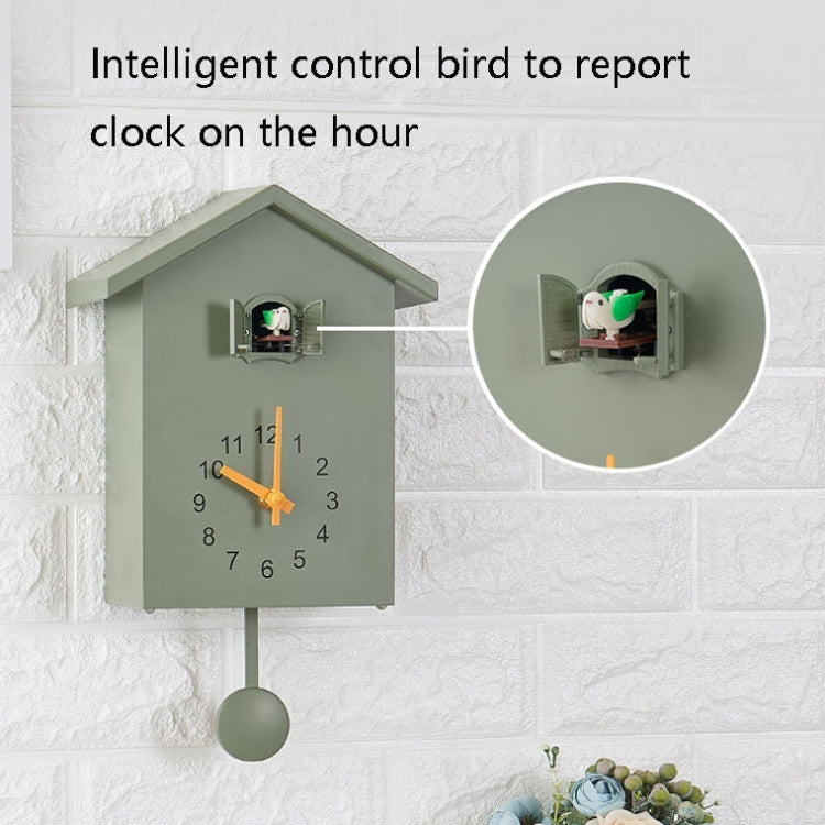 Green cuckoo wall clock with bird mechanism visible through front opening and hanging pendulum