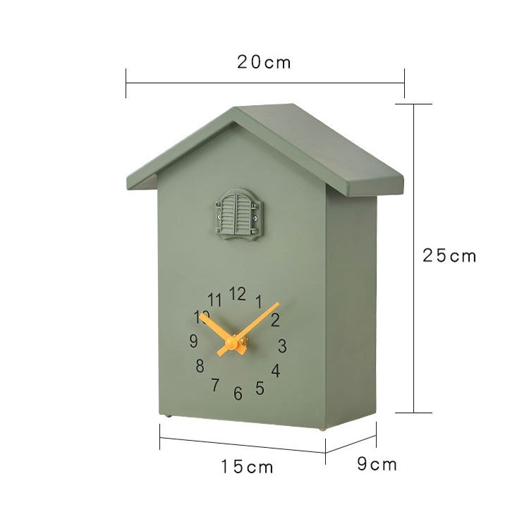 Cuckoo wall clock with green house body, gray roof, and orange clock hands