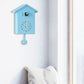 Blue cuckoo wall clock with clockface, pendulum weight, and bird compartment on top