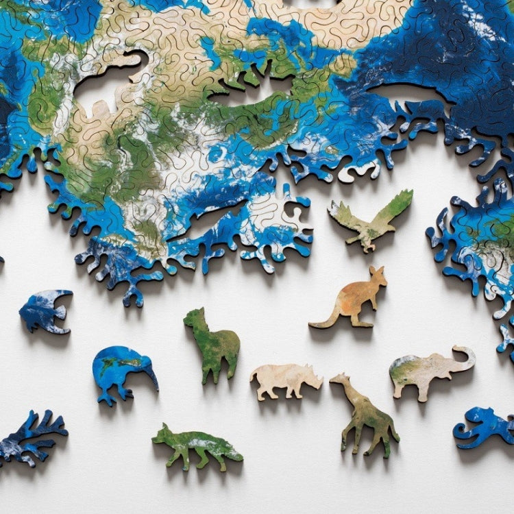Wooden puzzle board close-up with blue ocean, green land, and small animal pieces