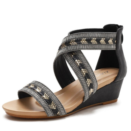 Black open-toe wedge sandals with crisscross strap detail and textured sole